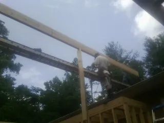 Carpenter setting a ridge beam over a new addition frame — Ice Dam Removal by Roofing Brothers in Lake Peekskill