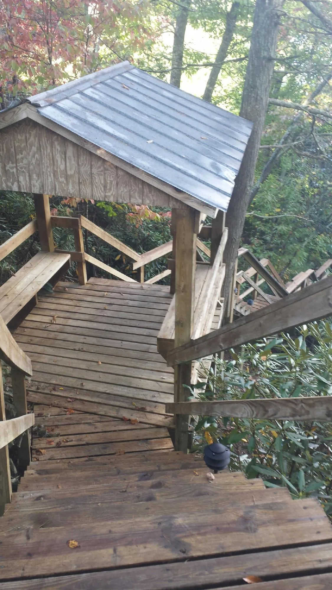 Metal roofed shelter over wooden steps on a wooded walkway — Skylight Repair & Installation work by our crew in Lake Peekskill