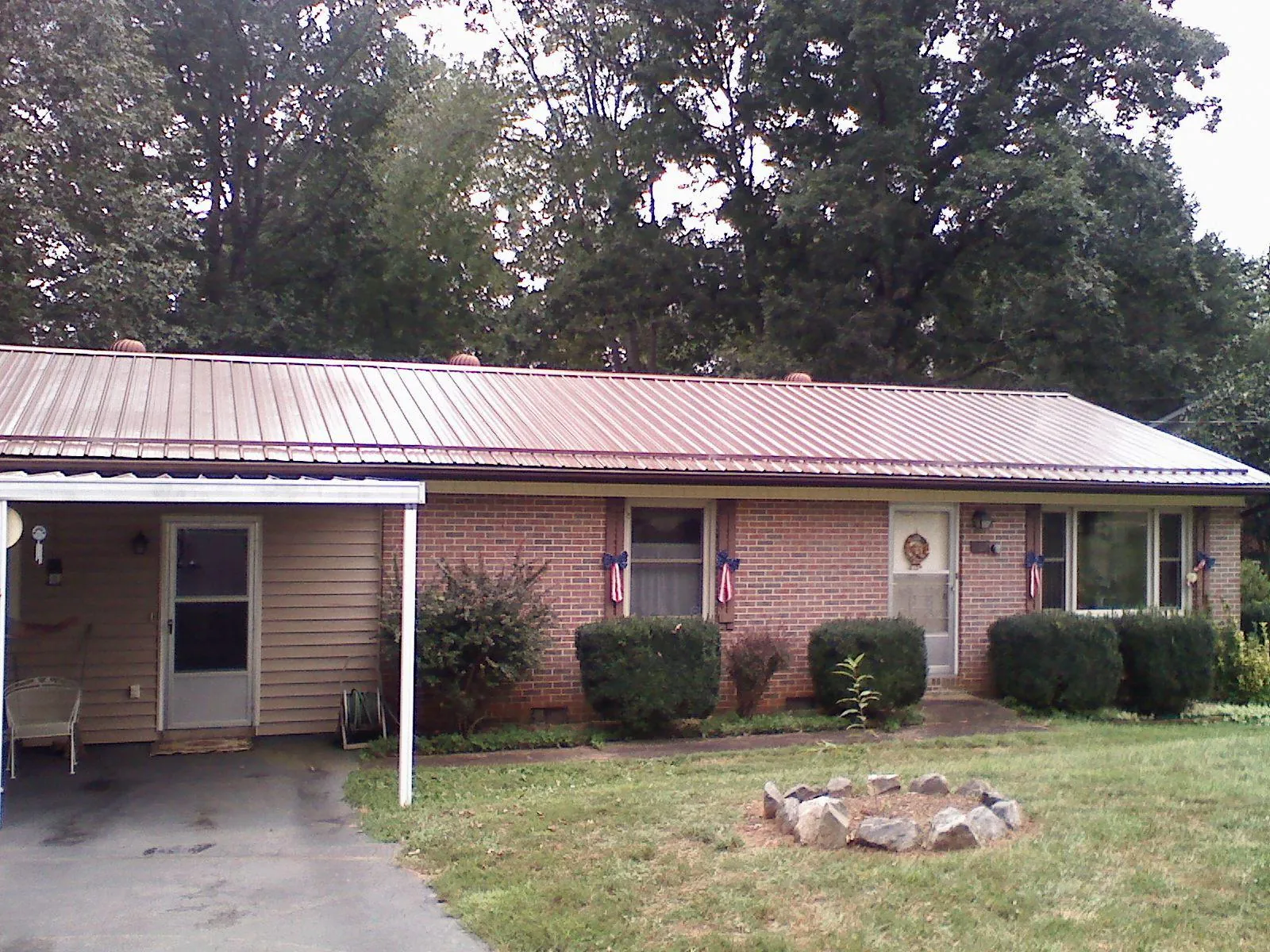 Bronze metal roof and carport on a brick ranch home — Roof Repair work by our crew in Lake Peekskill